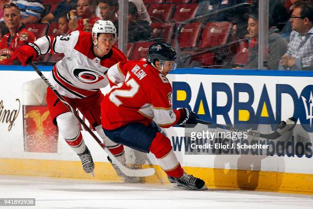 Denis Malgin of the Florida Panthers digs the puck from the boards against Jeff Skinner of the Carolina Hurricanes at the BB&T Center on April 2,...