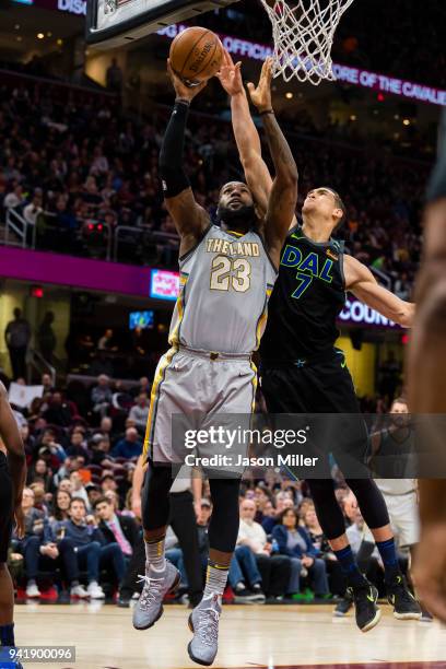 LeBron James of the Cleveland Cavaliers shoots a layup as Dwight Powell of the Dallas Mavericks makes the block during the second half at Quicken...