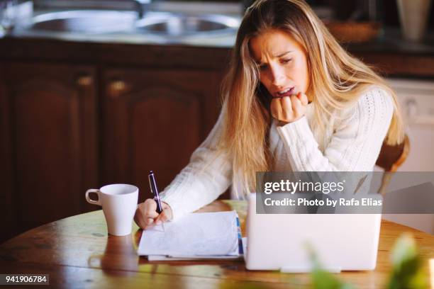 concerned woman checking bank account in laptop - confused writing stock-fotos und bilder