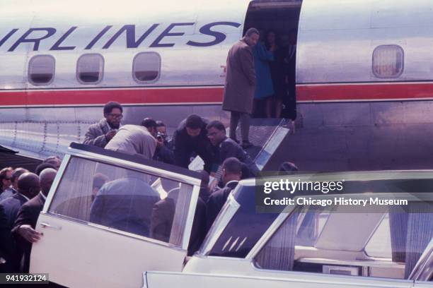 Group of men move the late Dr Martin Luther King Jr's casket from a hearse and up the loading ramp of an American Airlines plane on the tarmac at...