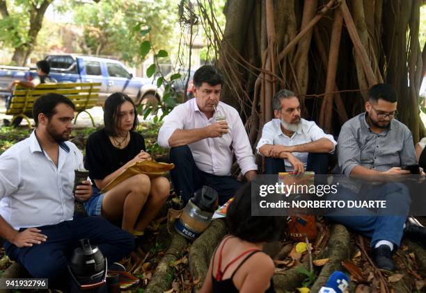 Paraguayan presidential candidate for the National Alliance party, Efrain Alegre and his running mate Leo Rubin share a round of mate with youths of...