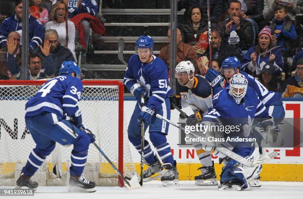 Auston Matthews of the Toronto Maple Leafs helps clear a puck for teammate Curtis McElhinney during action against the Buffalo Sabres in an NHL game...