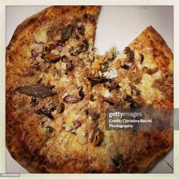pizza frutti do mare with one slice missing - christina plate stock pictures, royalty-free photos & images