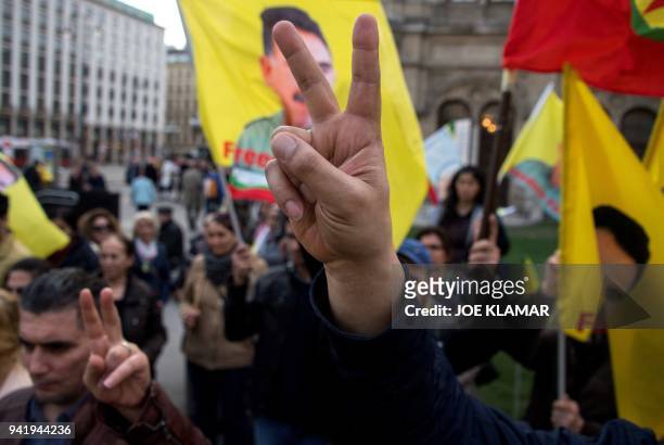 Protester flashes the sign of victory during a rally of members of the Kurdish community and their supporters to demand the release of jailed...
