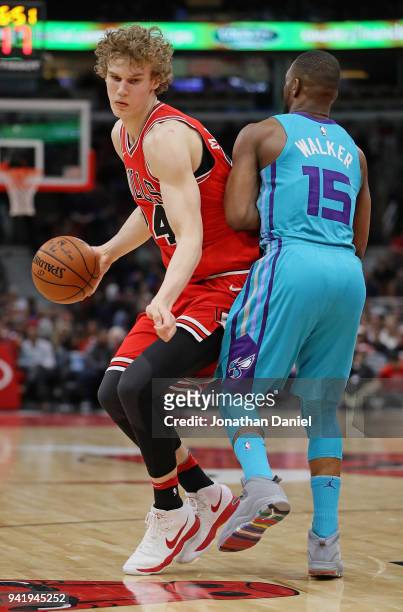 Lauri Markkanen of the Chicago Bulls moves against Kemba Walker of the Charlotte Hornets at the United Center on April 3, 2018 in Chicago, Illinois....