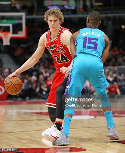 Lauri Markkanen of the Chicago Bulls moves against Kemba Walker of the Charlotte Hornets at the United Center on April 3, 2018 in Chicago, Illinois....