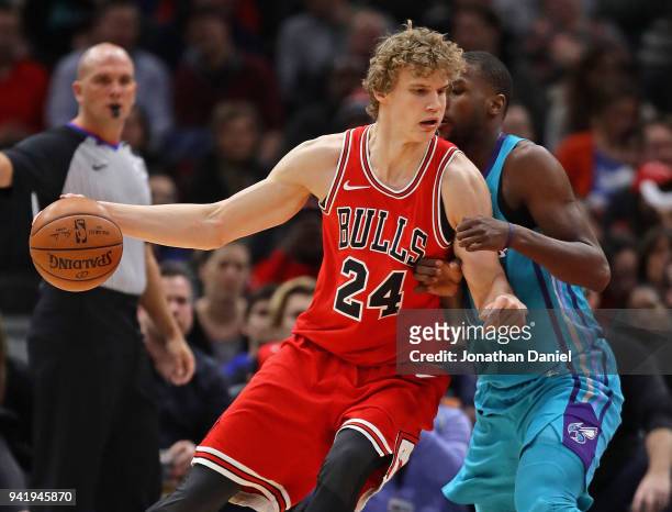 Lauri Markkanen of the Chicago Bulls moves against Michael Kidd-Gilchrist of the Charlotte Hornets at the United Center on April 3, 2018 in Chicago,...