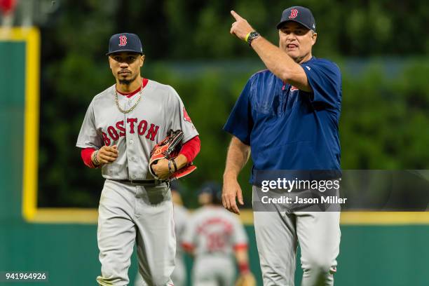 Mookie Betts is helped off the field by John Farrell of the Boston Red Sox after Betts suffered an injury during the eighth inning against the...