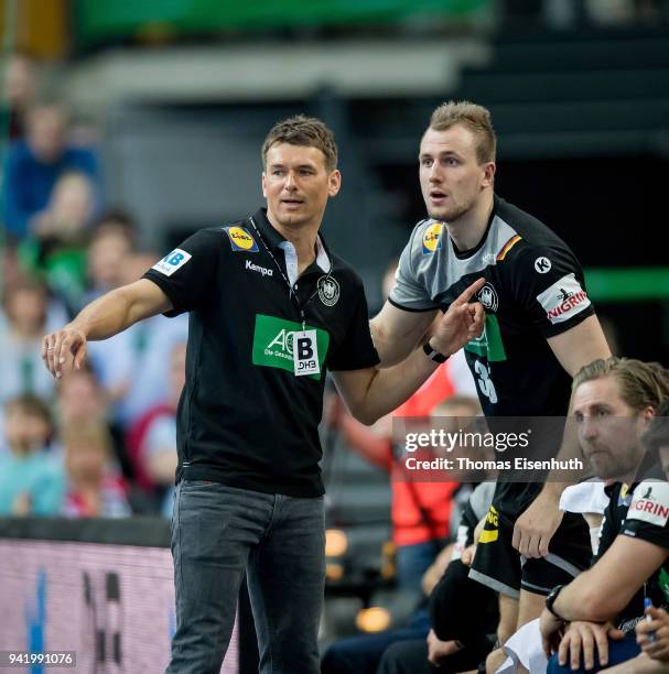 Coach Christian Prokop of Germany speaks to Julius Kuehn during the handball international friendly match between Germany and Serbia at Arena Leipzig...