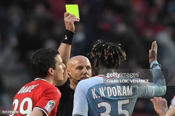 Monaco's French defender Kevin N'Doram receives a yellow card by French referee Amaury Delerue during the French L1 football match Rennes vs Monaco...