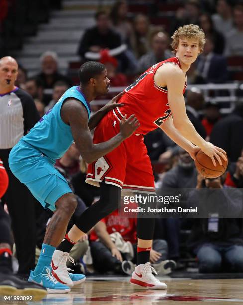 Lauri Markkanen of the Chicago Bulls looks to pass under pressure from Marvin Williams of the Charlotte Hornets at the United Center on April 3, 2018...