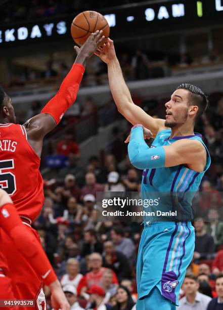 Willy Hernangomez of the Charlotte Hornets passes under pressure from Bobby Portis of the Chicago Bulls at the United Center on April 3, 2018 in...