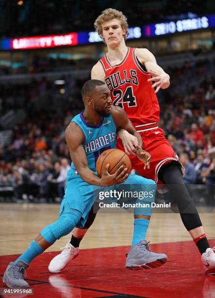 Kemba Walker of the Charlotte Hornets drives against Lauri Markkanen of the Chicago Bulls at the United Center on April 3, 2018 in Chicago, Illinois....