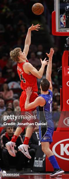 Lauri Markkanen of the Chicago Bulls shoots over Mario Hezonja of the Orlando Magic at the United Center on February 12, 2018 in Chicago, Illinois....