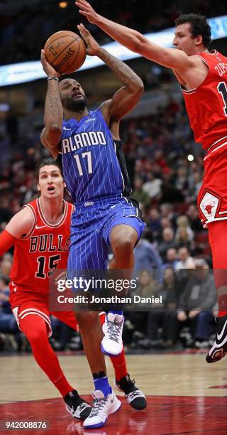 Jonathon Simmons of the Orlando Magic goes up between Ryan Arcidiacono and Paul Zipser of the Chicago Bulls at the United Center on February 12, 2018...