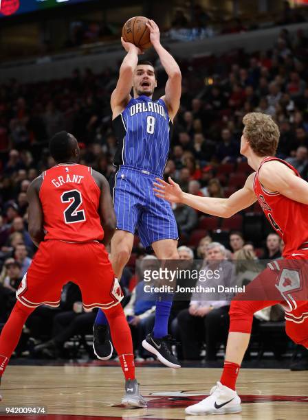 Mario Hezonja of the Orlando Magic shoots over Jerian Grant and Lauri Markkanen of the Chicago Bulls at the United Center on February 12, 2018 in...