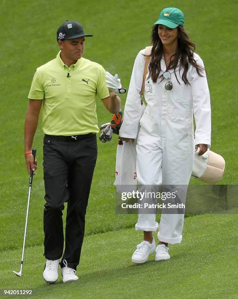 Rickie Fowler of the United States and girlfriend Allison Stokke walk together during the Par 3 Contest prior to the start of the 2018 Masters...