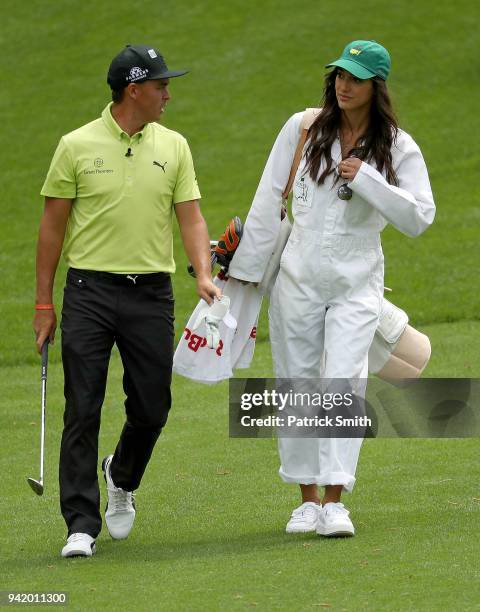 Rickie Fowler of the United States and girlfriend Allison Stokke walk together during the Par 3 Contest prior to the start of the 2018 Masters...