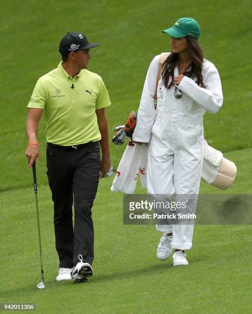 Rickie Fowler of the United States and girlfriend Allison Stokke walk together during the Par 3 Contest prior to the start of the 2018 Masters...