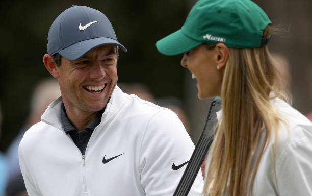 Rory McIlroy of Northern Ireland laughs with his wife Erica during the Par 3 Contest prior to the start of the 2018 Masters Tournament at Augusta...