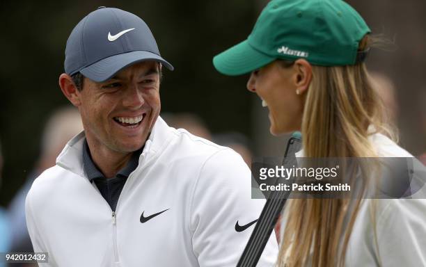Rory McIlroy of Northern Ireland laughs with his wife Erica during the Par 3 Contest prior to the start of the 2018 Masters Tournament at Augusta...