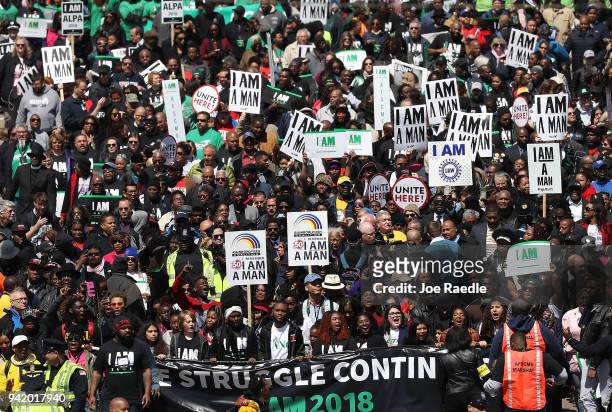 Marchers pass through the street during an event to mark the 50th anniversary of Dr. Martin Luther King Jr.'s assassination April 4, 2018 in Memphis,...