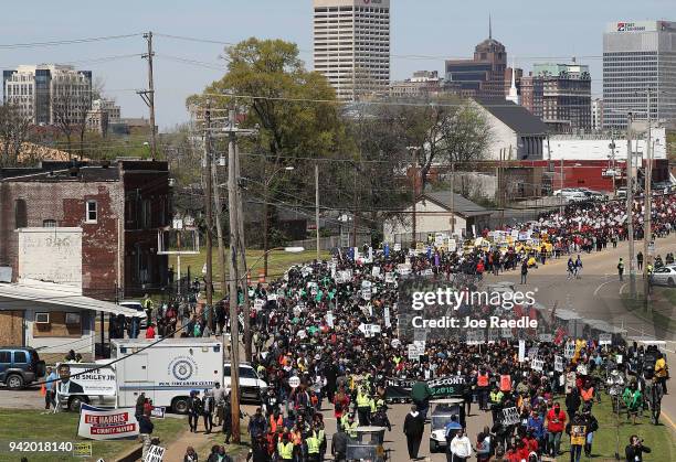 Marchers pass through the street during an event to mark the 50th anniversary of Dr. Martin Luther King Jr.'s assassination April 4, 2018 in Memphis,...