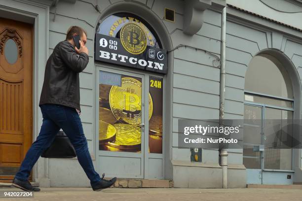 Man passes in front of a Bitcoin exchange shop in Wielopole Street in Krakow's city center. On Wednesday, April 4 in Krakow, Poland.