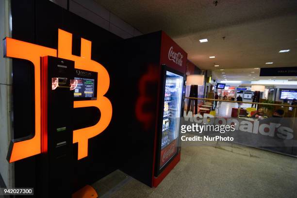 Bitcoin ATM, Coca Cola distributor and Mc Donald's restuarant in the background seen in Galeria Krakowska near the exit to Krakow's main train...