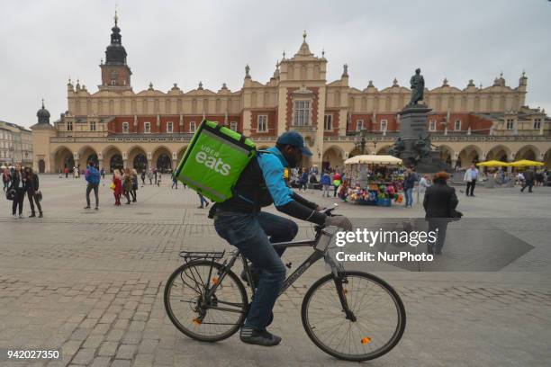 An 'Uber Eats' messanger passes by Rynek Square in front of the Cloth Hall in Krakow's Old Town. On Wednesday, April 4 in Krakow, Poland.