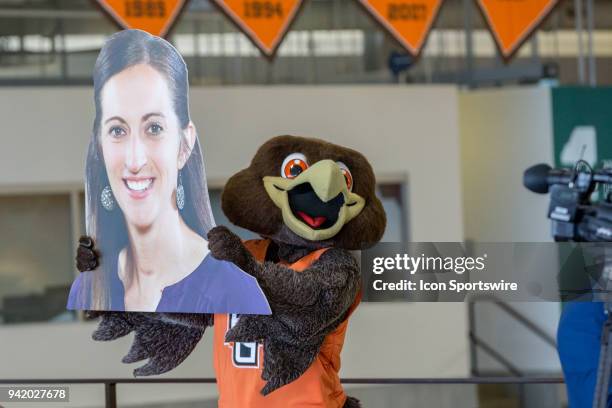 Bowling Green mascot Freddie Falcon holds a big head cutout of Robyn Fralick, who was introduced as the new head coach for the Bowling Green women's...