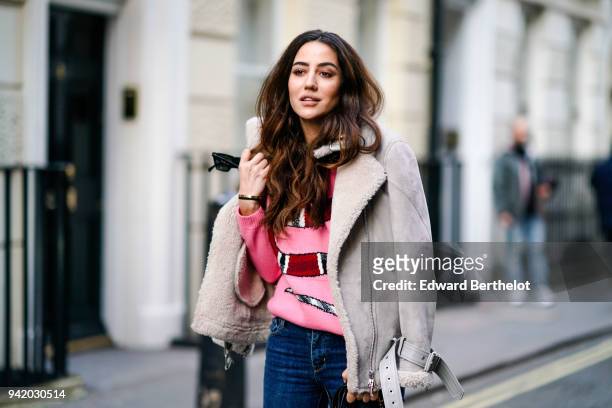 Tamara Kalinic wears a gray coat, a pink pull over, blue jeans pants, a Prada bag, green shoes, during London Fashion Week February 2018 on February...