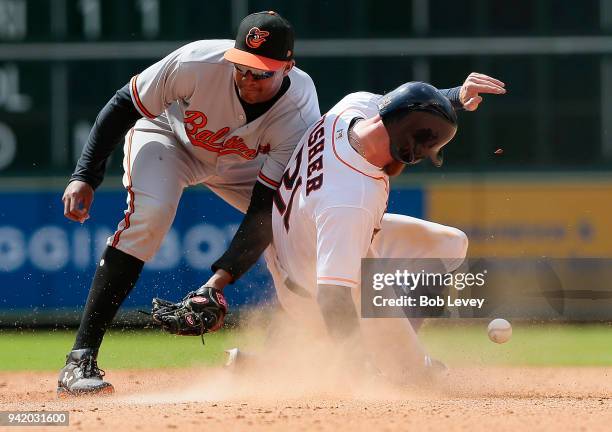 Derek Fisher of the Houston Astros steals second base as Jonathan Schoop of the Baltimore Orioles is unable to field the ball in the seventh inning...