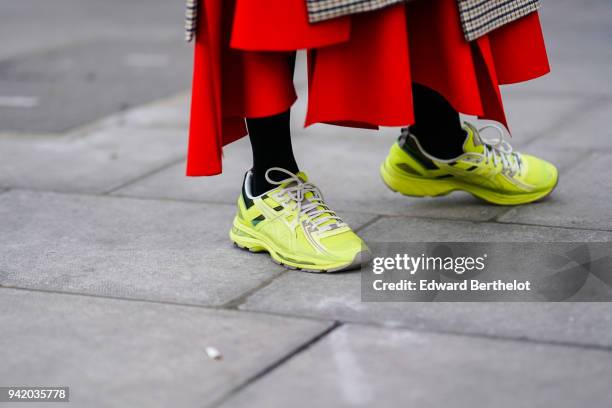 Guest wears yellow sneakers shoes, during London Fashion Week February 2018 on February 16, 2018 in London, England.