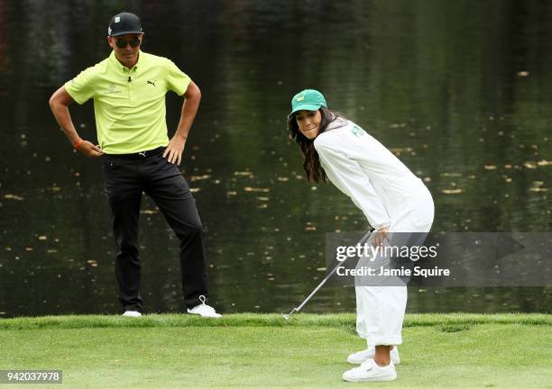 Rickie Fowler of the United States watches his girlfriend Allison Stokke during the Par 3 Contest prior to the start of the 2018 Masters Tournament...