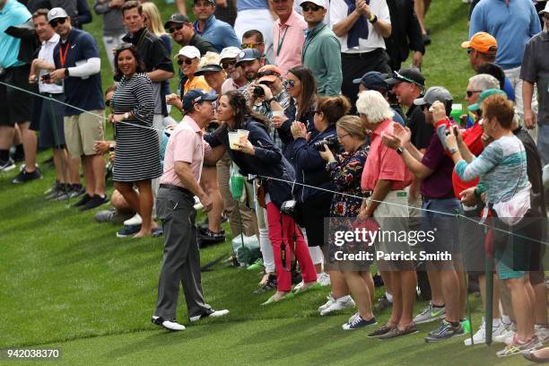 Tom Watson of the United States embraces a patron during the Par 3 Contest prior to the start of the 2018 Masters Tournament at Augusta National Golf...