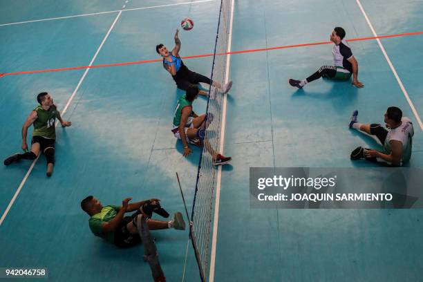 Colombian Army veterans, victims of land mines, take part in a practice session with Antioquia's Sitting Volleyball Team, on April 4, 2018 in...