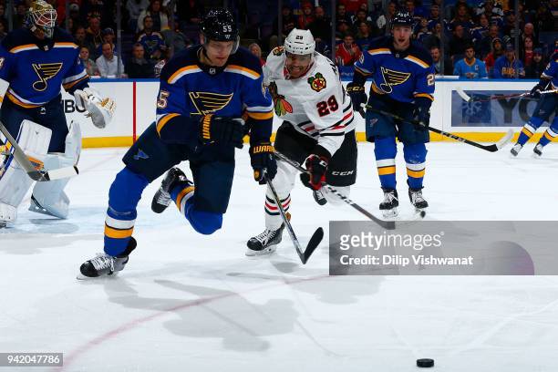 Colton Parayko of the St. Louis Blues and Andreas Martinsen of the Chicago Blackhawks chase down the puck at Scottrade Center on April 4, 2018 in St....
