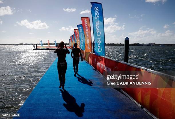 England's Jessica Learmonth and Sophie Coldwell walk onto the jetty toward the start line during the womens triathlon final during the 2018 Gold...