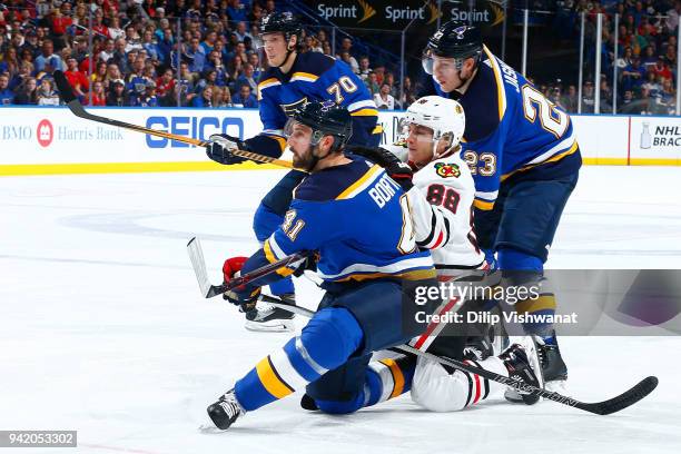 Robert Bortuzzo and Dmitrij Jaskin of the St. Louis Blues defend against Patrick Kane of the Chicago Blackhawks at Scottrade Center on April 4, 2018...