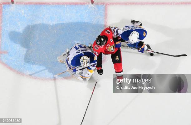 Chad Johnson of the Buffalo Sabres makes a save while Matt Duchene of the Ottawa Senators looks for a rebound during an NHL game on April 4, 2018 at...