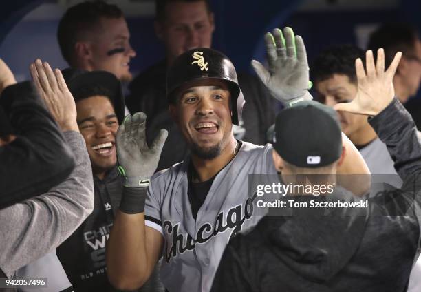 Jose Abreu of the Chicago White Sox is congratulated by teammates in the dugout after hitting a solo home run in the eighth inning during MLB game...