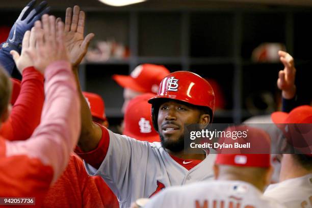 Dexter Fowler of the St. Louis Cardinals celebrates with teammates after scoring a run in the first inning against the Milwaukee Brewers at Miller...