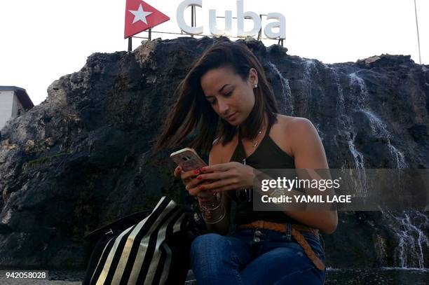 Cuban dancer Lisset Suarez checking internet in his cell phone in a street of Havana, on April 3, 2018. People from diverse places and different...