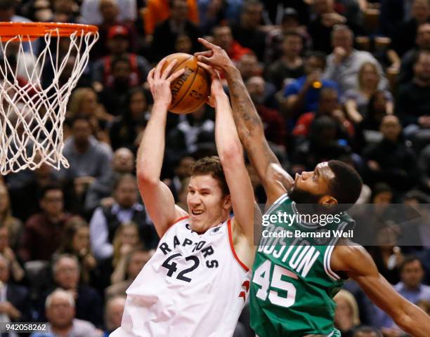 Boston Celtics guard Kadeem Allen stops Toronto Raptors center Jakob Poeltl to the basket but Peoltl hung on to score, in the 4th quarter as the...