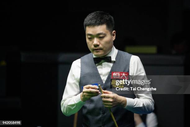 Ding Junhui of China chalks the cue in the second round match against Xiao Guodong of China during day three of the 2018 China Open at Olympic Sports...