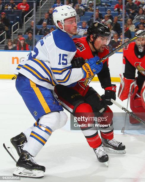 Jack Eichel of the Buffalo Sabres and Cody Ceci of the Ottawa Senators battle for position in front of the net during an NHL game on April 4, 2018 at...