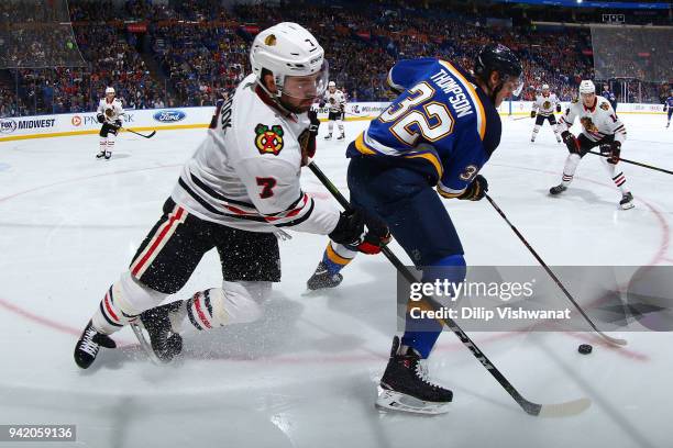 Brent Seabrook of the Chicago Blackhawks looks to steal the puck from Tage Thompson of the St. Louis Blues at Scottrade Center on April 4, 2018 in...