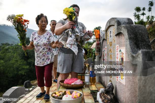 An ethnic Chinese Malaysian family pay their respects to their ancestor's grave at a cemetery during the annual Qingming festival in Karak, outside...