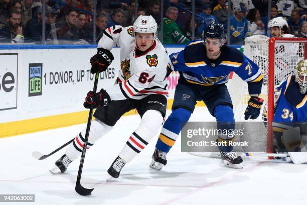 David Kampf of the Chicago Blackhawks handles the puck as Vladimir Sobotka of the St. Louis Blues pressures at Scottrade Center on April 4, 2018 in...